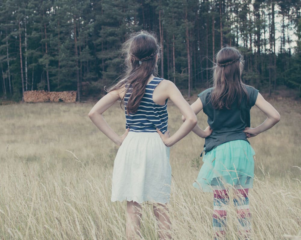 girls-standing-in-a-field girls-standing-in-a-field