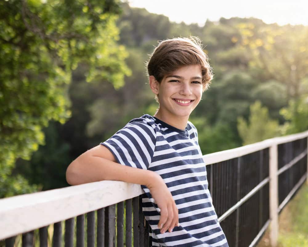 Teen-boy-leaning-next-to-a-fence Teen-boy-leaning-next-to-a-fence